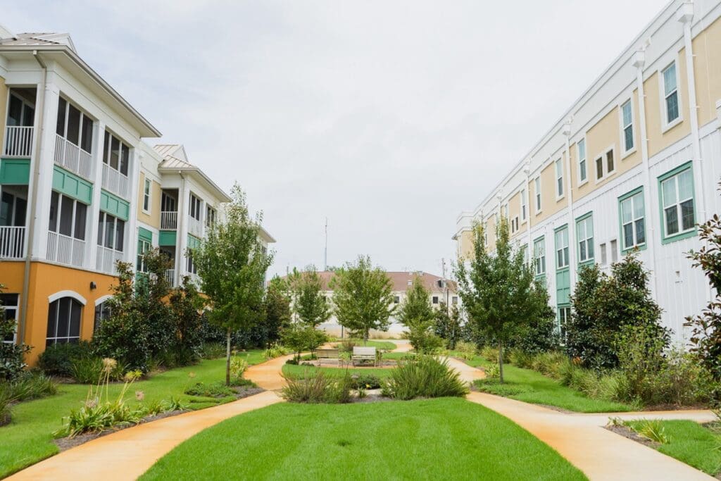 Exterior image of The Arbors of Gulf Breeze private courtyard with walking paths, beautiful scenery, and various seating throughout the garden.